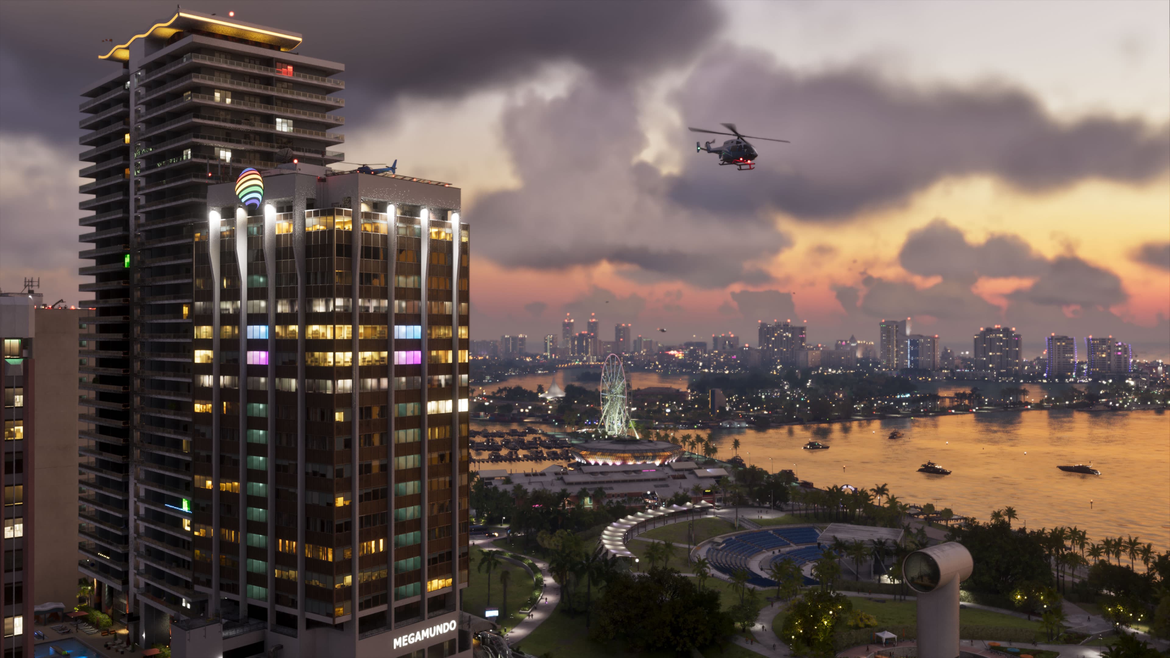 Vista de Vice City ao anoitecer, com prédios, helicóptero e a orla iluminada